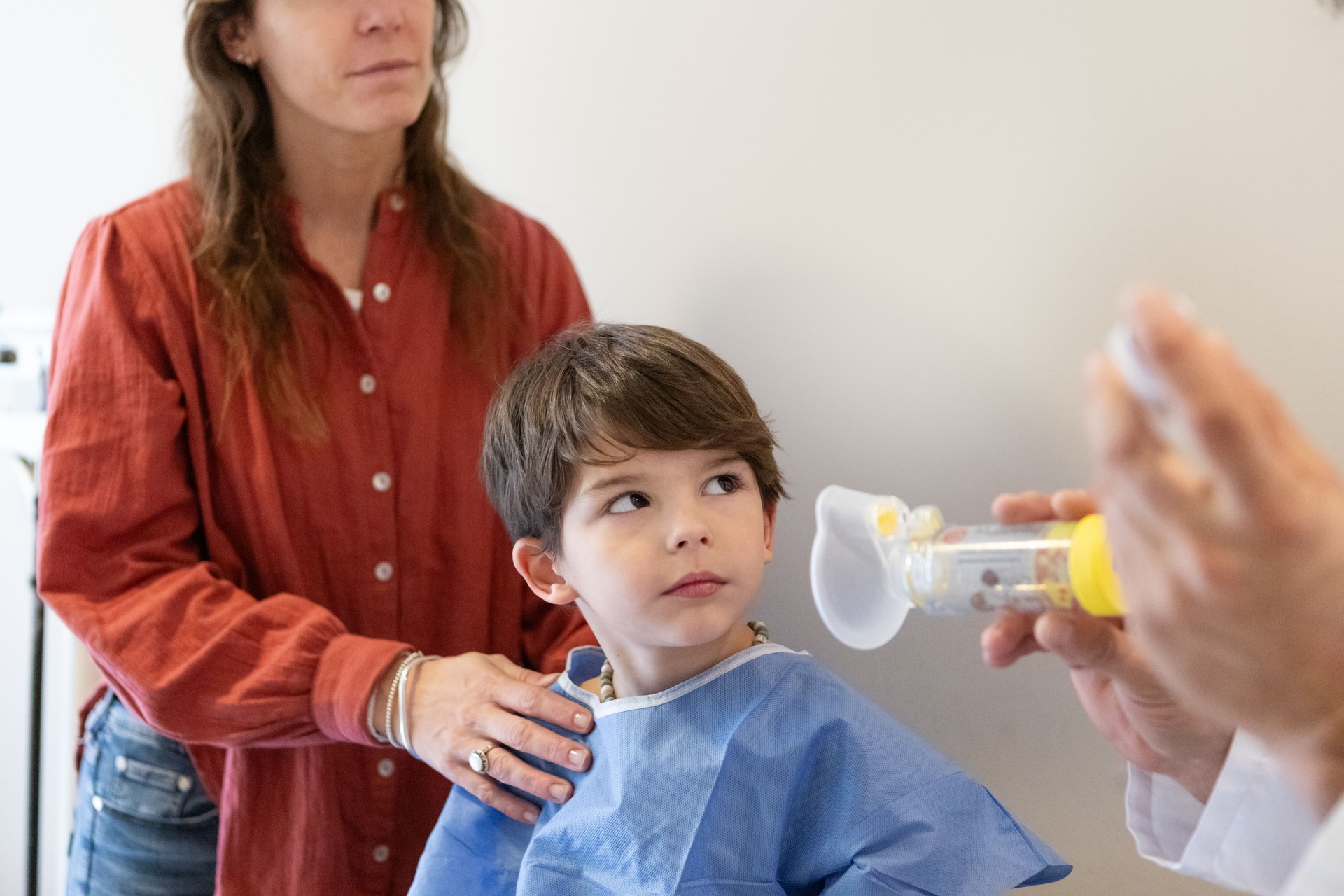 Child receiving a nebulizer treatment, during a medical checkup with a pediatrician